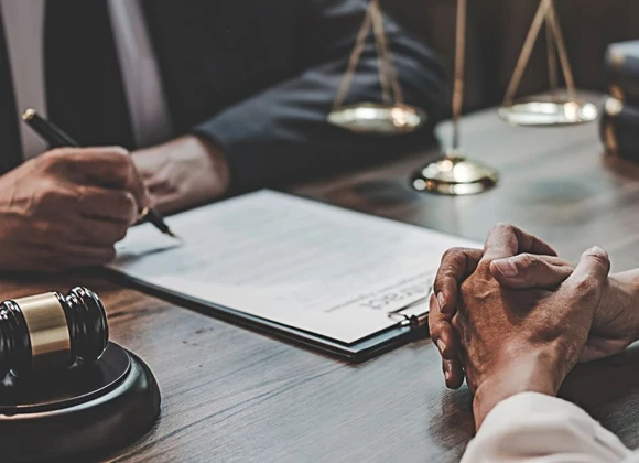 Close-up of hands featured in a discussion around legal papers, illustrating collaboration and professionalism in the bail bond process.
