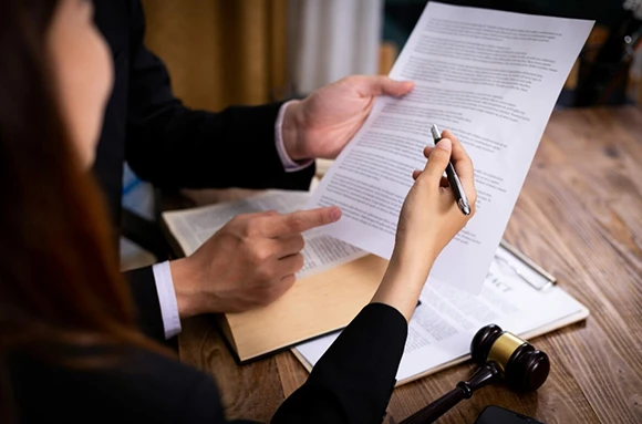 Close-up of two hands engaging over legal paperwork, illustrating a consultation regarding bail bond services, with a focus on professionalism and confidentiality in legal matters.