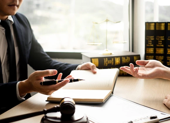 Individual reviewing documents while seated at a desk, showcasing the process of managing affordable bail bonds and client consultations.