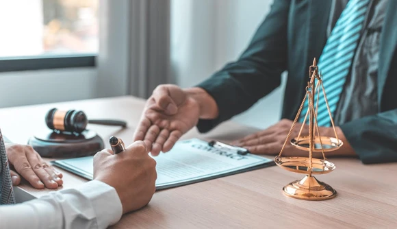 Close-up of hands assisting in the review of legal paperwork, demonstrating the process of affordable bail bonds in a professional setting.