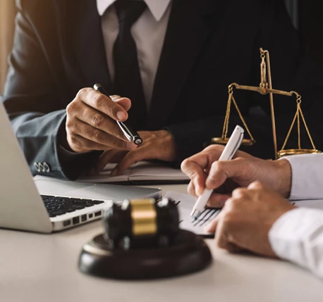 Close-up of a gavel next to scales of justice on a desk, symbolizing the legal process and the importance of fair representation in bail bonds.