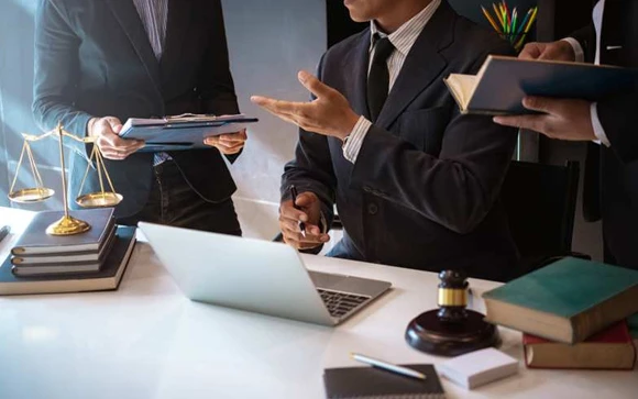 Two individuals engaging in a discussion over legal documents at a desk, highlighting collaboration in the fast bail bond process.